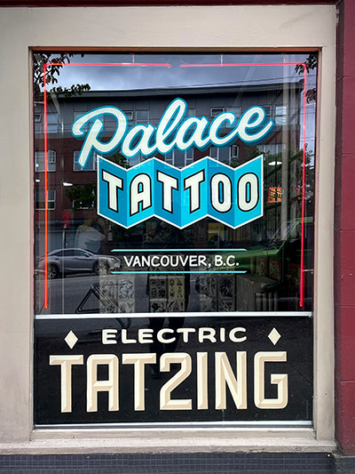 Palace Tattoo - front window showing brush-lettered hand painted signage.